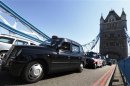 Taxi drivers in traditional black cabs drive slowly across Tower Bridge in protest at not being allowed to drive in the Olympic Lanes during the London 2012 Olympic Games
