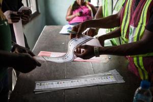 An assessor holds a ballot paper in a polling station …