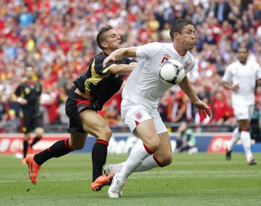 England's Gary Cahill (R) is tackled by Belgium's Dries Mertens