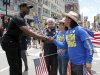 NBA veteran Jason Collins, left, the first active player in one of four major U.S. professional sports leagues to come out as gay, shakes hand with Boston Marathon hero Carlos Arredondo, as they both participated in Boston's gay pride parade, Saturday, June 8, 2013, in Boston. Looking on is former Congressman Barney Frank, second from left. (AP Photo/Mary Schwalm)