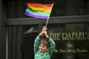A young boy waves rainbow flag while watching the San Francisco gay pride parade in San Francisco, California