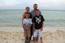 In this August 2011 photo provided by Arrica Wallace, Wallace poses with her husband, Matthew, and sons Marccus and Mason in Mexico during a vacation, two weeks after her first round of chemotherapy. Arrica Wallace was 35 when her cervical cancer was discovered in 2011. It spread widely, with one tumor so large that it blocked half of her windpipe. The strongest chemotherapy and radiation failed to help, and doctors gave her less than a year to live. But her doctor heard about an immune therapy trial at the Cancer Institute and got her enrolled. "It's been 22 months since treatment and 17 months of completely clean scans" that show no sign of cancer, Arrica Wallace said. (AP Photo/Courtesy Arrica Wallace)