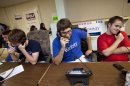 In this photo taken June 29, 2012, Geoffrey Tanner, 19, of Herndon, Va., center, and other volunteers make phone calls at the Romney Victory Office in Fairfax, Va. Call them passionate, idealistic, earnest, even a tad naive: The volunteers helping to power the Obama and Romney campaigns are outliers at a time when polls show record low public satisfaction with government and a growing belief that Washington isn’t on their side. While motivated by opposing goals, the Obama and Romney volunteers share at least one key trait: an abiding faith in the political process and a belief that it still matters who occupies the White House. (AP Photo/Jacquelyn Martin)