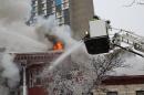 Crews battle a Minneapolis apartment fire on Wednesday, Jan. 1, 2014. The billowing fire engulfed a three-story building, sending 13 people to hospitals with injuries ranging from burns to trauma associated with falls. (AP Photo/Jeff Baenen)