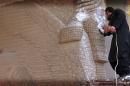 An image grab taken off a video reportedly released by Welayat Nineveh Media Office on February 26, 2015, allegedly shows an IS militant destroying the statue of an Assyrian diety with a jackhammer in the northern Iraqi Governorate of Nineveh