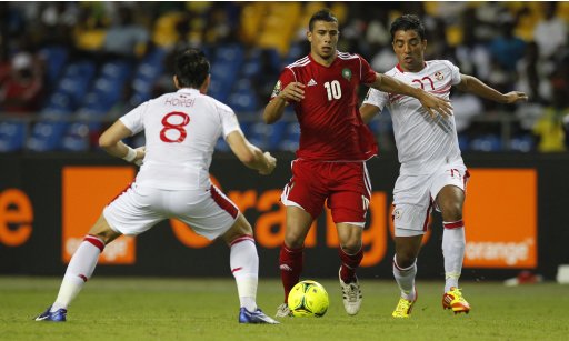 Morocco's El Ahmadi Aroussi dribbles the ball past Tunisia's Korbi Khaled and Allagui Sami during their African Cup of Nations Group C soccer at Stade De L'Amitie Stadium in Libreville