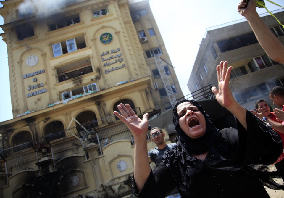 An Egyptian woman chants slogans, as protesters ransack the Muslim Brotherhood headquarters in the Muqattam district in Cairo, Monday, July 1, 2013. Protesters stormed and ransacked the headquarters of President Mohammed Morsi's Muslim Brotherhood group early Monday, in an attack that could spark more violence as demonstrators gear up for a second day of mass rallies aimed at forcing the Islamist leader from power. (AP Photo/Khalil Hamra)
