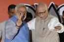 Opposition Bharatiya Janata Party (BJP) leader and India's next prime minister Narendra Modi, left, flashes the victory symbol standing next to senior party leader L.K. Advani at the party headquarters in New Delhi, India, Saturday, May 17, 2014. Thousands of cheering supporters welcomed Modi on his arrival in the capital Saturday after leading his party to a staggering victory in national elections. Modi and his BJP wiped out the Congress party that dominated Indian politics for all but a decade since the country gained freedom from British rule in 1947. (AP Photo/Altaf Qadri)