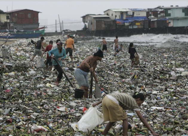 A group of people gather salvagable materials from debris washed ashore due to Typhoon Nanmadol Saturday, Aug. 27, 2011 in Manila, Philippines. Forecasters said the typhoon hit the northeastern tip of