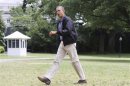 Obama walks across the South Lawn as he returns via Marine One helicopter from a weekend visit at Camp David to the White House in Washington