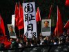 Anti-Japan protesters hold portraits of the late Communist leader Mao Zedong, Chinese national flags, and a poster that reads: "Sept. 18, National Humiliation Day," while marching on a street outside the Japanese Embassy in Beijing Tuesday, Sept. 18, 2012. The 81st anniversary of a Japanese invasion brought a fresh wave of anti-Japan demonstrations in China on Tuesday, with thousands of protesters venting anger over the colonial past and a current dispute involving contested islands in the East China Sea. (AP Photo/Alexander F. Yuan)