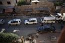 Vehicles of a UN and SARC aid convoy, with food, nutrition, health and other emergency items, enter the rebel-held town of Douma, east of the Syrian capital Damascus, on June 10, 2016