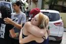 Ciera Rogers, far right, receives condolences from her friend Sam Hinde, on the loss of Rogers' grandfather, who was shot and killed the night before on a sidewalk near his home, in the northern Colorado town of Loveland, Colo., Thursday, June 4, 2015. At left, facing, Emmett Pelissier hugs Ciera Rogers' sister Sadie. The overnight killing in this northern Colorado city has raised alarm that a serial shooter might be trolling the area's roads after a bicyclist was gunned down and a driver was wounded nearby in less than two months. (AP Photo/Brennan Linsley)