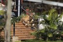 A Kenyan soldier holding a dog by its leash enters the main gate of Westgate Shopping Centre in Nairobi