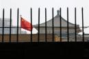 The national flag of China flutters behind a fence of the headquarters of the NDRC in Beijing