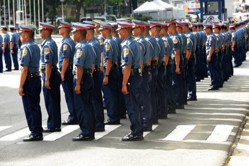 Philippine police officers stand at attention during a gathering at the Philippine National Police headquarters in suburban Manila in 2011. A Philippine policeman has been detained in connection with the kidnapping and murder of a woman after he was caught on camera driving the victim's vehicle, an official said on Tuesday