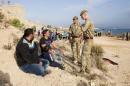 Handout shows British soldiers speaking to migrants on a beach at RAF Akrotiri in Cyprus