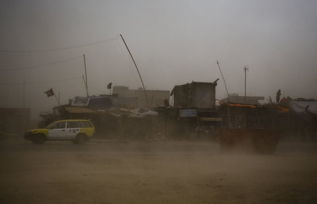 A taxi tries to make its way through a sandstorm that obscures the city of Kanadahar, Afghanistan, Sunday April 21, 2013. (AP Photo/Anja Niedringhaus)
