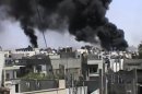 In this image made from amateur video released by the Shaam News Network and accessed Wednesday, April 18, 2012, black smoke rises from buildings in Khaldiyeh district, Homs, Syria. Nearly a week after a cease-fire took effect, Syrian troops pounded a rebel stronghold Wednesday as the country's foreign minister met with his Chinese counterpart in Beijing during the latest round of talks aimed at preventing the truce from unraveling. (AP Photo/Shaam News Network via AP video) TV OUT, THE ASSOCIATED PRESS CANNOT INDEPENDENTLY VERIFY THE CONTENT, DATE, LOCATION OR AUTHENTICITY OF THIS MATERIAL