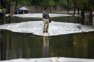 A person turns back from crossing floodwaters, Thursday, Sept. 8, 2011, in the Manayunk neighborhood of Philadelphia. Widespread flooding brought on by the remnants of Tropical Storm Lee was being blamed for two deaths in Pennsylvania, where inundated communities were evacuated and state offices closed down on Thursday because of the rising waters. (AP Photo/Matt Rourke)