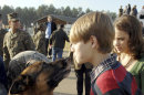 FILE - This Dec. 21, 2007 photo shows German Shepard dog Lex and one of his new owners Camryn Lee get closer together after the adoption ceremony at the Marine Corps Logistics Base in Albany, Ga. The bomb-sniffing military dog, who made national headlines when he was adopted by his fallen Marine handler's family, died March 25 in Starkville, Miss., where he had been undergoing cancer treatment at the Mississippi State University veterinary school. A 2007 rocket explosion in Iraq killed Cprl. Dustin Lee and injured Lex. The Mississippi House on Friday, April 20, 2012, adopted a resolution honoring Lex. (AP Photo/Walter Petruska, File)