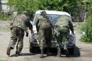 Pro-Russian separatists push a car before driving to the battle line in Seversk
