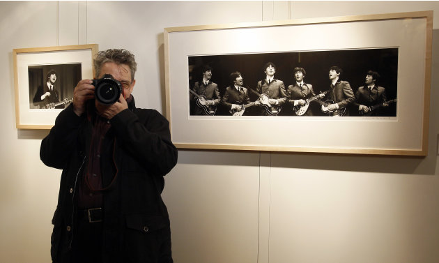 Photographer Mike Mitchell takes pictures of photographers whilst he stands by some of his photographs of The Beatles where they are being exhibited at a hotel in London, Friday, June 10, 2011. The pr