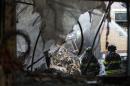 New York City emergency responders search through the rubble at the site of a building explosion in the Harlem section of New York