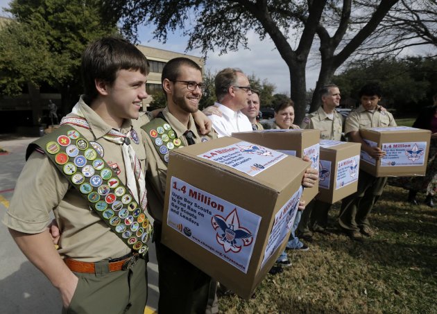 FILE - In this Feb. 4, 2013 file photo, James Oliver, left, hugs his brother and fellow Eagle Scout, Will Oliver, who is gay, as Will and other supporters carry four boxes filled with a petition to end the ban on gay scouts and leaders in front of the Boy Scouts of America headquarters in Dallas, Texas. Under pressure over its long-standing ban on gays, the Boys Scouts of America is proposing to lift the ban for youth members but continue to exclude gays as adult leaders. The Scouts announced Friday, April 19, 2013 that the proposal would be submitted to the roughly 1,400 voting members of its National Council at a meeting in Texas the week of May 20, 2013. (AP Photo/Tony Gutierrez, File)