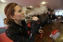 FILE - In this Feb. 20, 2014 photo, Talia Eisenberg, co-founder of the Henley Vaporium, uses her vaping device in New York. Soon, the Food and Drug Administration will propose rules for e-cigarettes. The rules will have big implications for a fast-growing industry and its legions of customers. (AP Photo/Frank Franklin II, File)