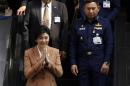 Thailand's PM Yingluck gestures as she leaves the Royal Thai Air Force Headquarters in Bangkok