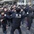 A policeman tries to drag away people who refused to leave the Apple Store in Beijing Friday, Jan. 13, 2012. An angry crowd shouted and threw eggs at Apple's Beijing flagship store after it failed to open on schedule Friday to sell the popular new iPhone 4S model. (AP Photo/Andy Wong)