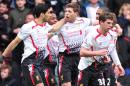 Liverpool's English midfielder Steven Gerrard (C) is congratulated by teammates including Liverpool's Uruguayan striker Luis Suarez (L) after scoring at Upton Park in London on April 6, 2014