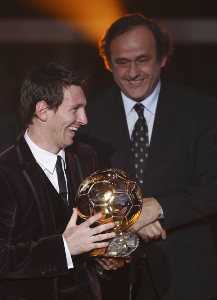 Messi of Argentina, FIFA World Player of the Year holds his FIFA Ballon d'Or 2011 trophy next to UEFA President Platini during the FIFA Ballon d'Or 2011 soccer awards ceremony in Zurich