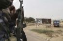 Chadian soldiers drive past a signpost painted by Boko Haram in the recently retaken town of Damasak