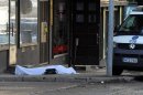 A body covered with a sheet lies on the street in Hyvinkaa, Finland, Saturday May 26, 2012. A gunman in southern Finland has killed one person and wounded eight others in what appeared to be a random shooting, police said Saturday. (AP Photo/Lehtikuva/Sari Gustafsson) FINLAND OUT
