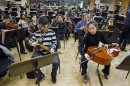 Two members of North Korea's Unhasu Orchestra prepare their instruments as they take part in a rehearsal with the Radio France Philharmonic Orchestra in Paris, Tuesday, March 13, 2012. Musicians from the Unhasu Orchestra will perform a piece together with Radio France Philharmonic Orchestra, directed by South Korean conductor Chung Myung-whun, in Paris, Wednesday, March 14. (AP Photo/Remy de la Mauviniere)