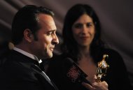Jean Dujardin winner of best actor for this work in "The Artist" looks at his Oscar award at the Governors Ball following the 84th Academy Awards on Sunday, Feb. 26, 2012, in the Hollywood section of Los Angeles. (AP Photo/Chris Pizzello)