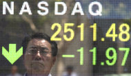 A man checking stock prices is reflected on the electronic stock board of a securities firm in Tokyo showing 11.97 points, or 0.5 percent fall of the Nasdaq composite to 2,511.48 Thursday, Aug. 18, 2011. Asian stocks sank Thursday after Japan announced that exports had fallen for the fifth straight month in July and weak forecasts in the U.S. fed fears of a second recession. (AP Photo/Koji Sasahara)
