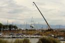 A large crane lifts a boat out of the Great Salt Lake Marina because of low water levels, west of Salt Lake City