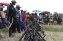 Militants from the Democratic Forces for the Liberation of Rwanda (FDLR) stand near a pile of weapons after their surrender in Kateku