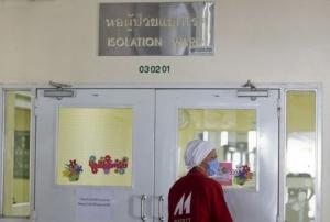A worker wearing a mask walks outside the isolation ward where a businessman from Oman is being treated for MERS at the Bamrasnaradura Infectious Diseases Institute in Nonthaburi province