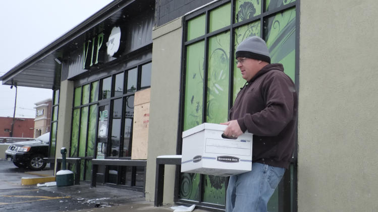 Agentes federales retiran una caja del dispensario de marihuana VIP Cannabis en Denver, el jueves 21 de noviembre de 2013, durante un allanamiento a diversos establecimientos de este tipo en la ciudad. (AP Foto/Ed Andrieski)