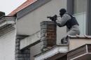 A member of the special forces takes position on a roof near the site of a shooting in the southern Forest district of Brussels on March 15, 2016
