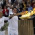 Torchbearers light up a cauldron with the Olympic Flame at the Panathenaic stadium in Athens