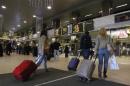 Romanians carry their luggage for a flight to Heathrow airport in Britain, at Otopeni international airport near Bucharest