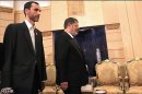 Egypt's President Mohamed Mursi stands next to Iran's Executive Vice President Hamid Baghai during their meeting at Mehrabad airport in Tehran