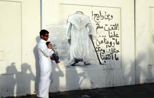 A Saudi carrying his baby poses at a mural dedicated&nbsp;&hellip;