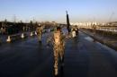 File photo shows a member of Afghan security forces holding up his rifle as he walks at the site of an attack in Kabul