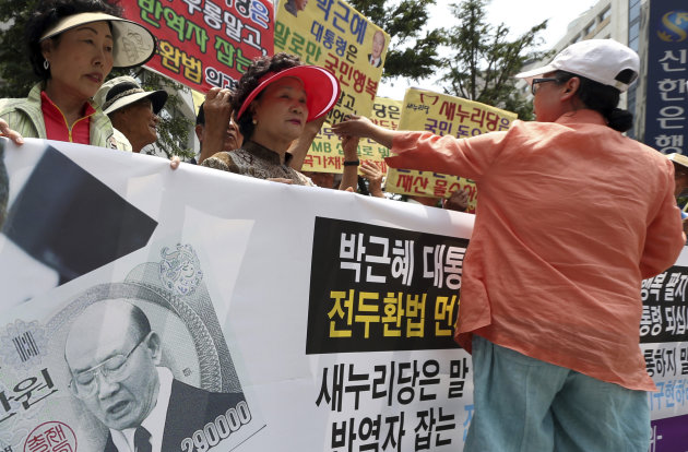 South Korean protesters stage a rally demanding their government to recover former South Korean President Chun Doo-hwan's slush fund in front of the ruling Saenuri Party headquarters in Seoul, South Korea, Monday, June 24, 2013. Prosecutors are racing against time to collect 167 billion won ($144 million) from Chun’s slush fund - a hunt meant to help close one of modern South Korea’s darkest chapters. The letters at a banner read: "President Park Geun-hyun must punish Chun Doo-hwan according the the law." (AP Photo/Yonhap, Bae Jung-hyun) KOREA OUT